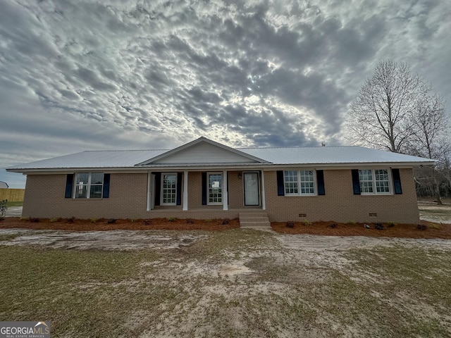 single story home with crawl space, brick siding, and metal roof