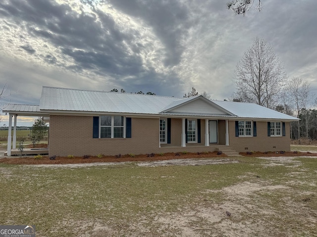 ranch-style home featuring crawl space, brick siding, and metal roof