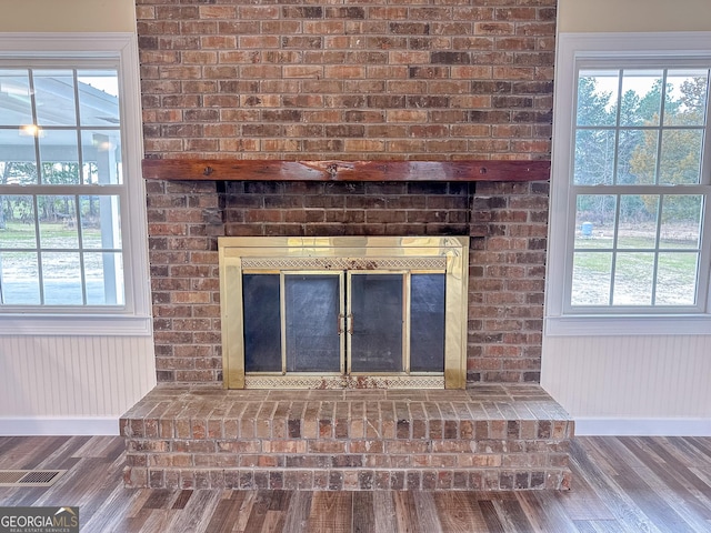 room details featuring a fireplace, baseboards, and wood finished floors