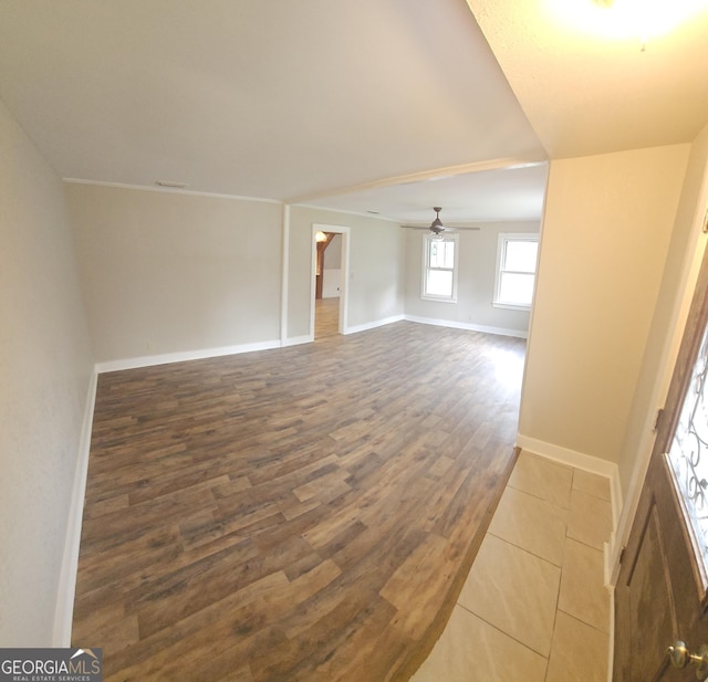 unfurnished room featuring dark wood-style floors, baseboards, and a ceiling fan