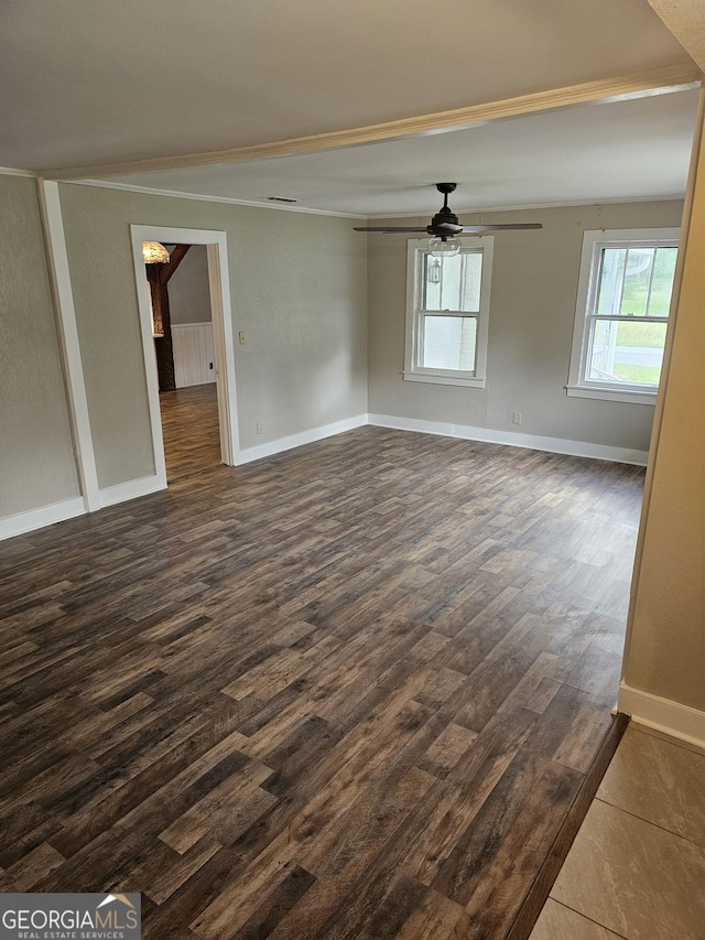 empty room with a ceiling fan, dark wood finished floors, and baseboards