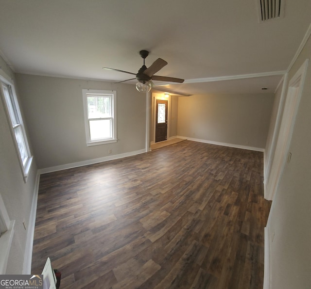 interior space with dark wood-type flooring, a ceiling fan, visible vents, and baseboards