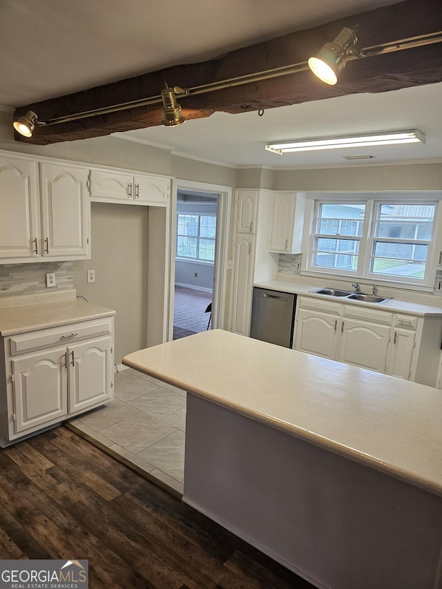 kitchen featuring white cabinets, backsplash, dark wood-style flooring, stainless steel dishwasher, and a sink