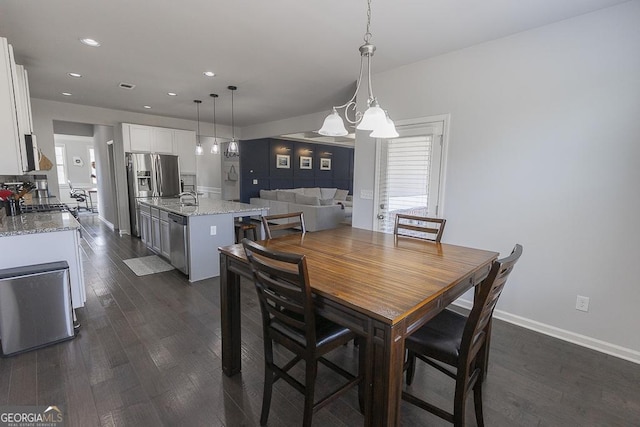 dining room with a wealth of natural light, recessed lighting, and dark wood-style flooring