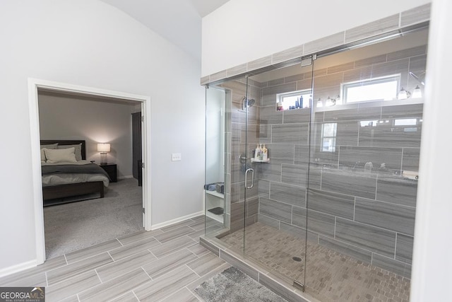 bathroom with a stall shower, baseboards, and ensuite bathroom