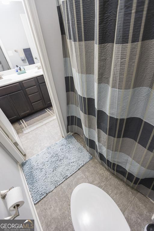 full bath with double vanity and a shower with curtain