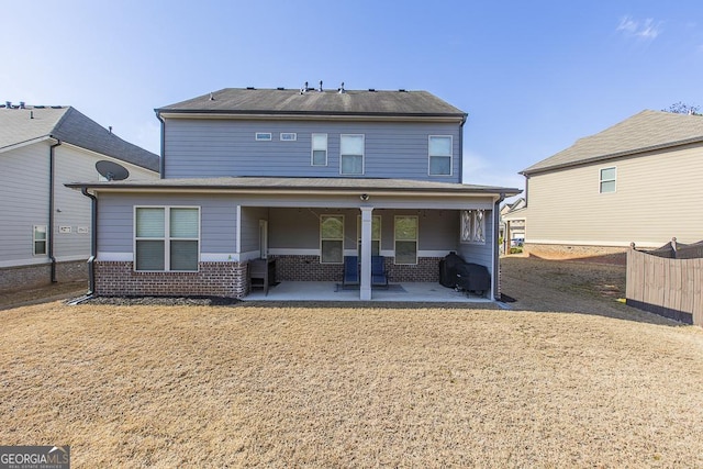 back of property with a patio, brick siding, and fence