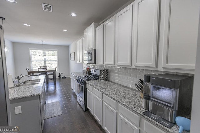 kitchen with tasteful backsplash, dark wood-type flooring, stainless steel appliances, a sink, and recessed lighting