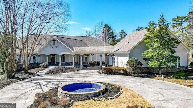 view of front of property with curved driveway and stucco siding