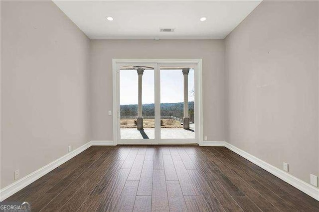 spare room featuring dark wood-type flooring, recessed lighting, visible vents, and baseboards