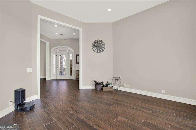 unfurnished room featuring recessed lighting, wood finished floors, and baseboards