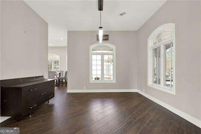 interior space featuring dark wood-type flooring, visible vents, and baseboards