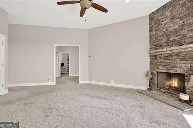 unfurnished living room featuring ceiling fan, a fireplace, carpet flooring, and baseboards