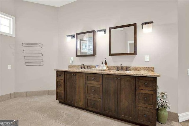 bathroom with tile patterned flooring, a sink, and double vanity