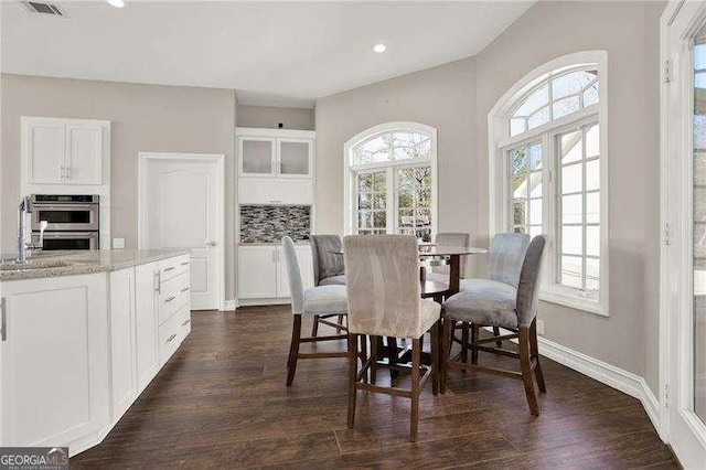 dining space with a healthy amount of sunlight, visible vents, and dark wood finished floors