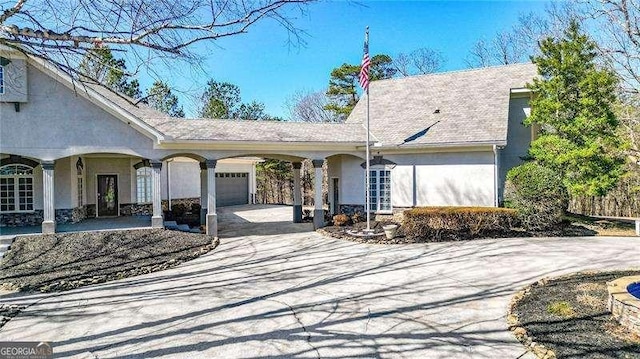 view of front of home featuring driveway, a carport, an attached garage, and stucco siding