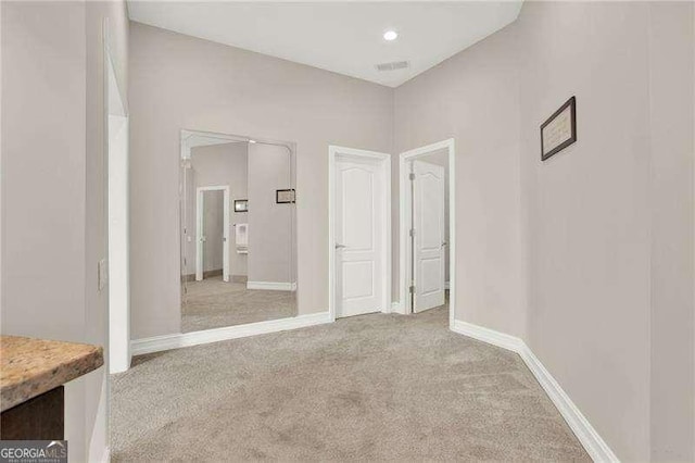 unfurnished bedroom featuring light carpet, visible vents, and baseboards