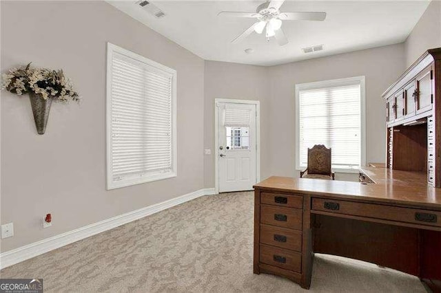 office area featuring baseboards, a ceiling fan, visible vents, and light colored carpet