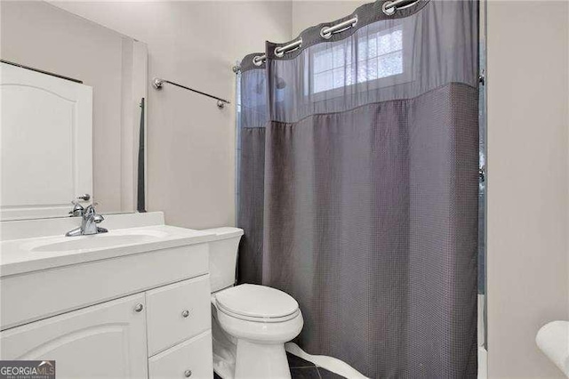 bathroom featuring toilet, shower / bath combination with curtain, and vanity