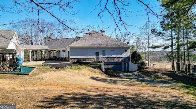 back of house featuring stucco siding, fence, and a yard