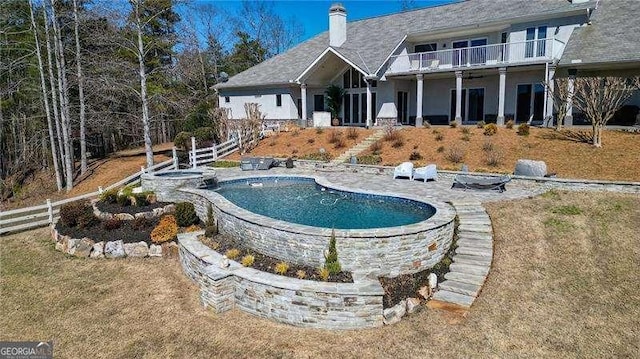 view of swimming pool with a pool with connected hot tub, a patio area, fence, and stairway