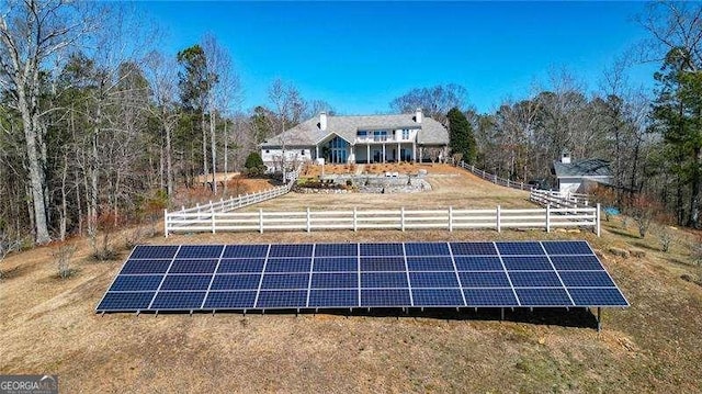 rear view of house featuring solar panels