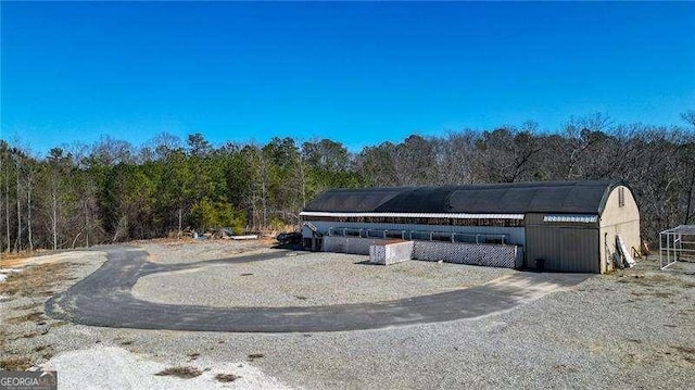 view of home's community featuring a forest view and an outdoor structure