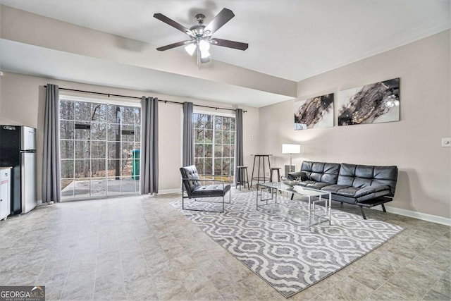 living room with ceiling fan and baseboards