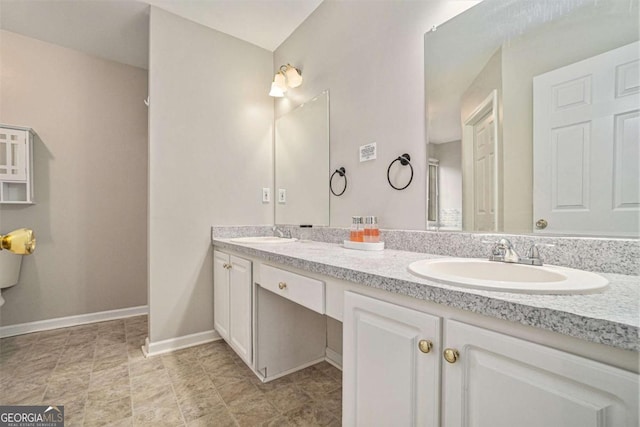 full bathroom featuring a sink, baseboards, and double vanity