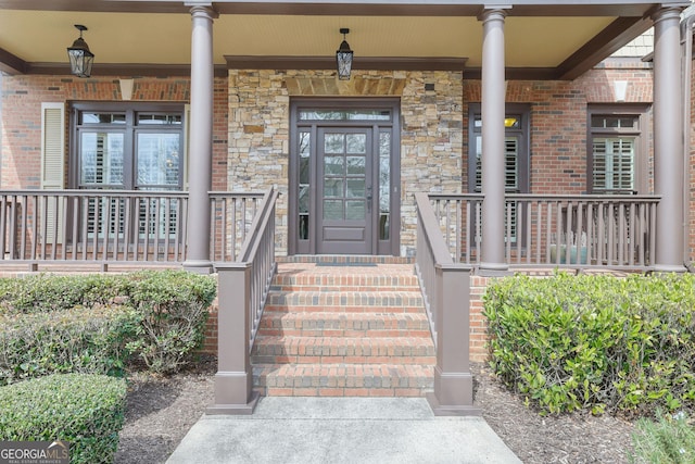 entrance to property featuring a porch and stone siding