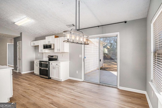 kitchen featuring visible vents, light wood-style flooring, stainless steel appliances, light countertops, and white cabinets