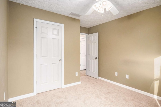 unfurnished bedroom featuring visible vents, baseboards, carpet, and a textured ceiling