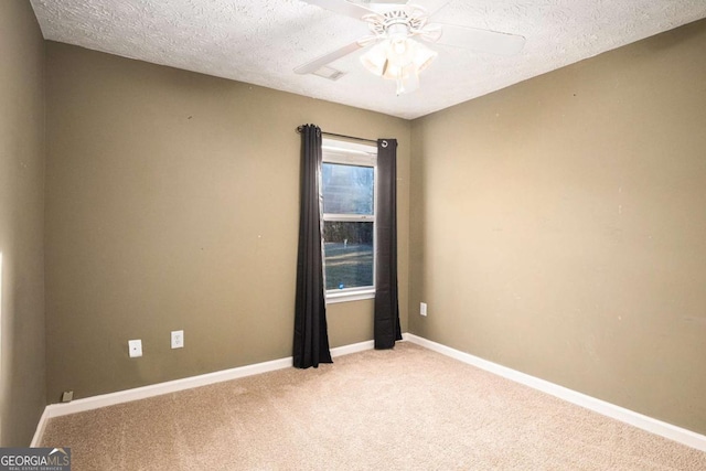 unfurnished room featuring baseboards, light carpet, a textured ceiling, and ceiling fan