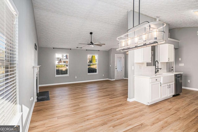 kitchen featuring a ceiling fan, light wood-style flooring, a sink, white cabinets, and dishwasher