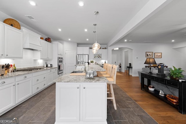 kitchen featuring visible vents, recessed lighting, arched walkways, stainless steel appliances, and a sink