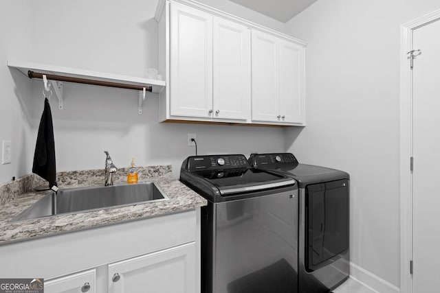 laundry area with a sink, cabinet space, baseboards, and separate washer and dryer