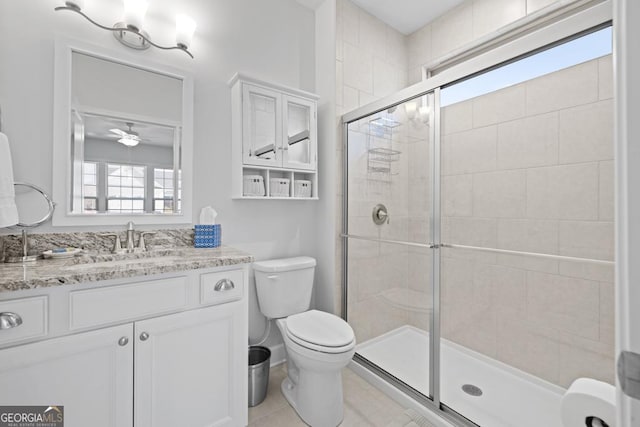 full bath with vanity, a shower stall, toilet, and ceiling fan