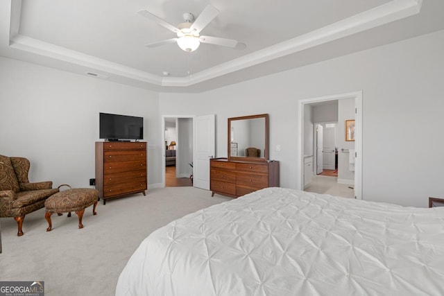 bedroom featuring a ceiling fan, visible vents, light carpet, a raised ceiling, and connected bathroom