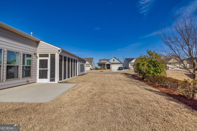 view of yard featuring a sunroom and a patio area