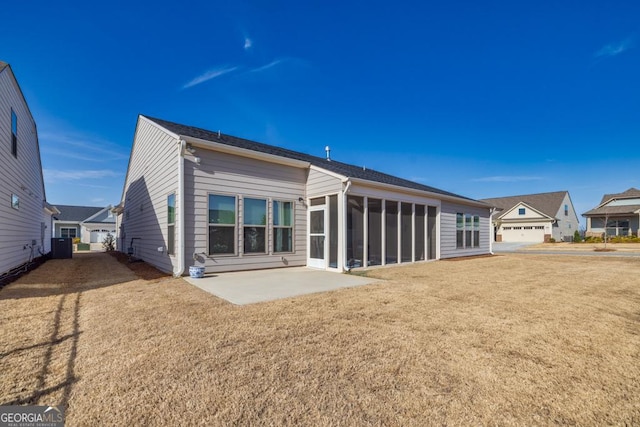 back of property with a patio, a yard, and a sunroom