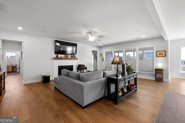 living room with recessed lighting, a brick fireplace, baseboards, and wood finished floors