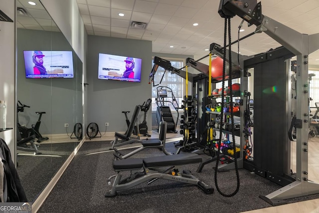 gym with baseboards, visible vents, and a drop ceiling