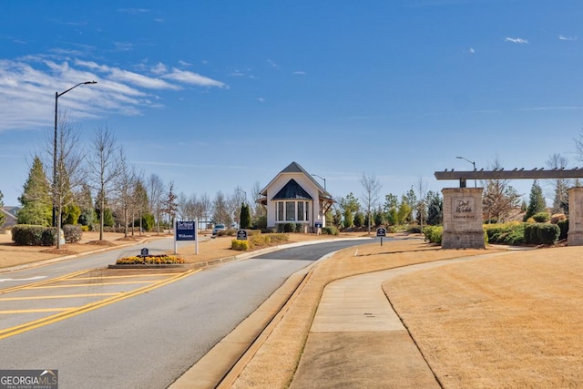 view of road featuring curbs, street lights, and sidewalks