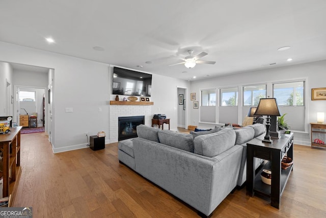 living area featuring wood finished floors, baseboards, a fireplace, recessed lighting, and ceiling fan