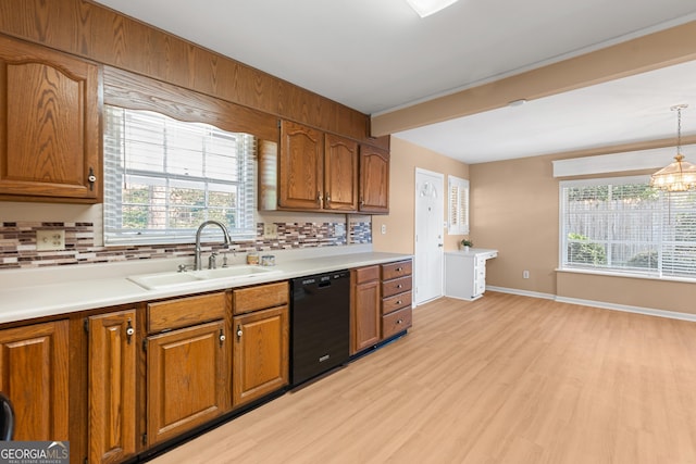 kitchen featuring black dishwasher, decorative backsplash, a sink, and brown cabinets