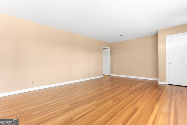 empty room with light wood-type flooring and baseboards