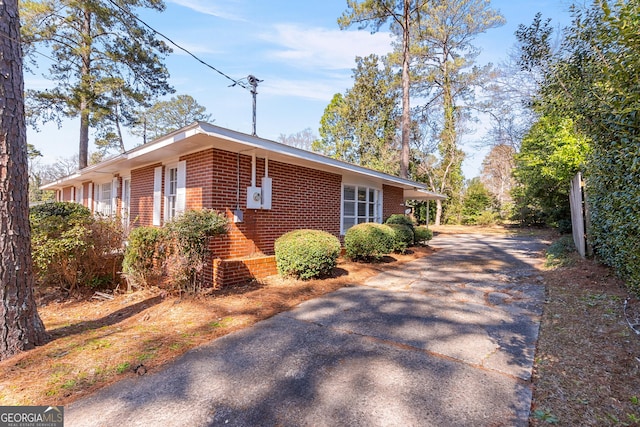 view of home's exterior featuring brick siding and aphalt driveway