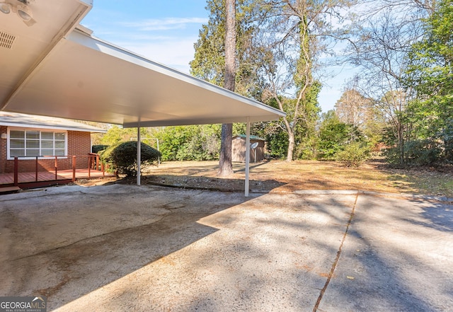 view of vehicle parking featuring concrete driveway and a storage unit