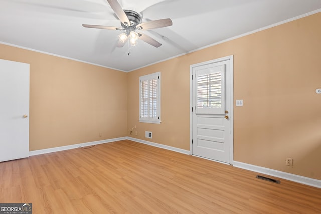 interior space featuring light wood-type flooring, baseboards, visible vents, and ornamental molding