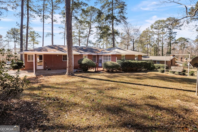 rear view of house with brick siding and a lawn